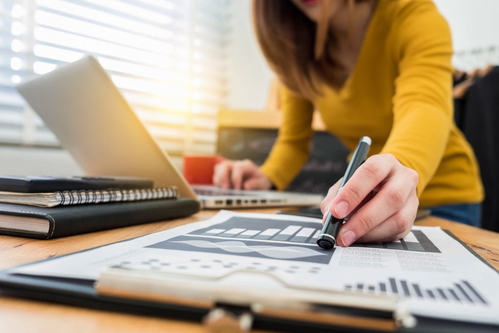 Frau analysiert Geschäftsdaten am Schreibtisch