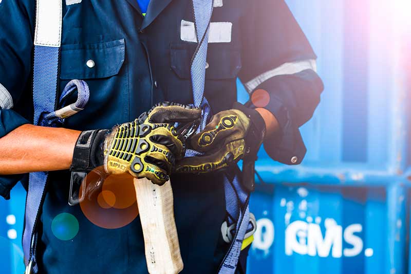 Feuerwehrmann mit Ausrüstung vor blauem Container