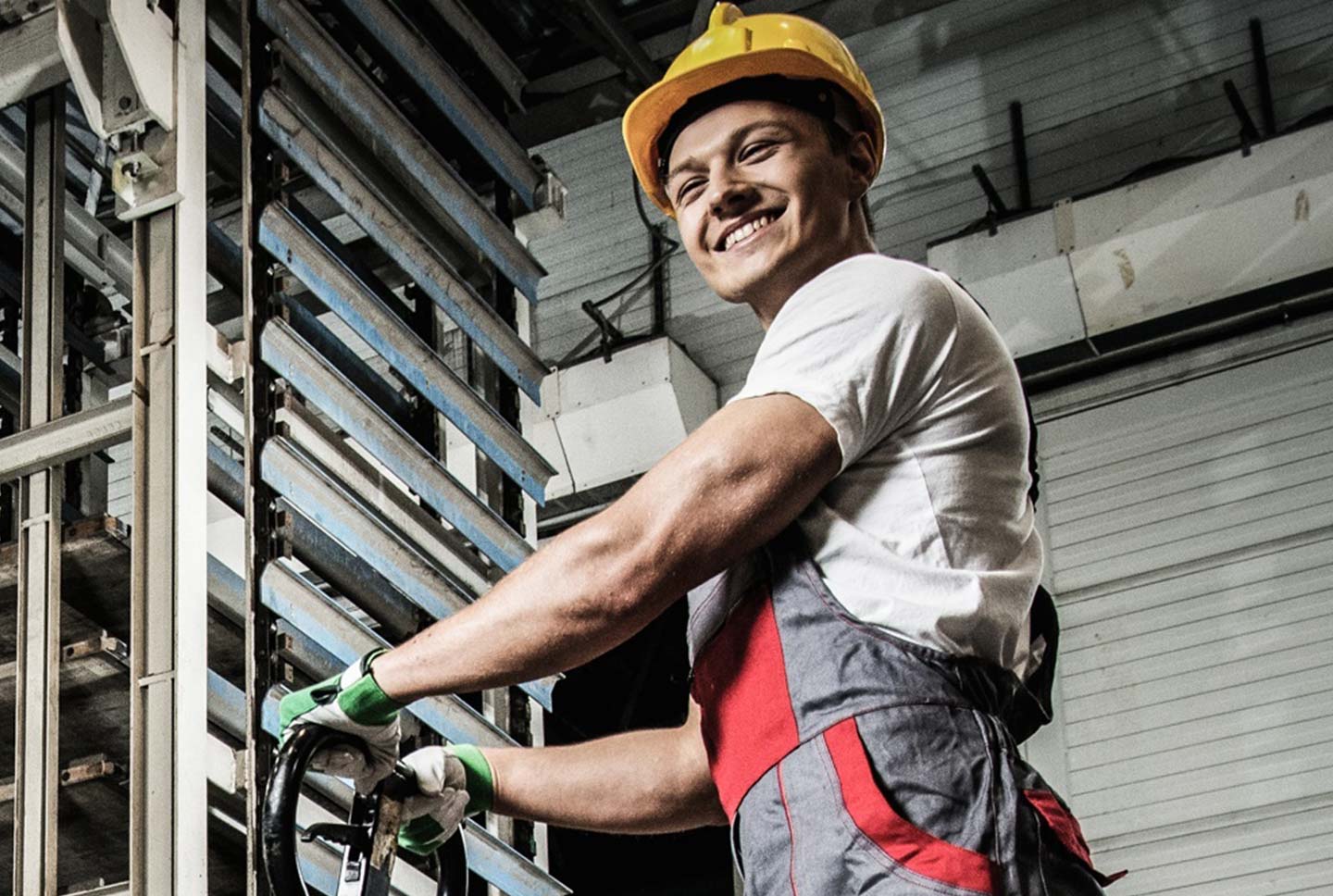 Lächelnder Arbeiter mit Helm bei der Arbeit