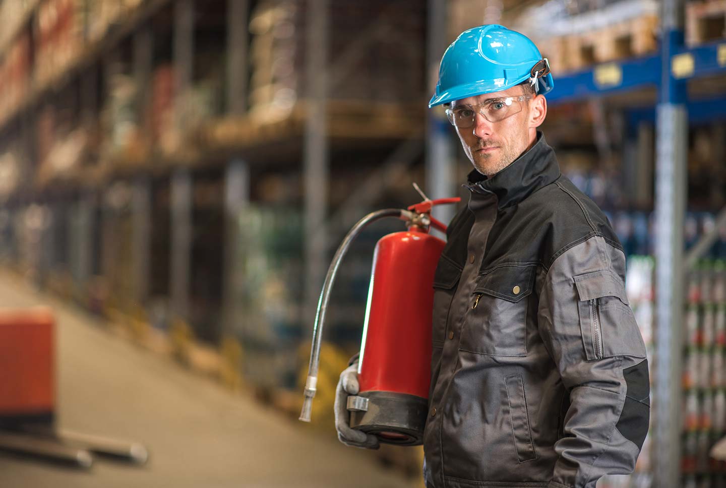 Arbeiter mit Feuerlöscher in Lagerhalle