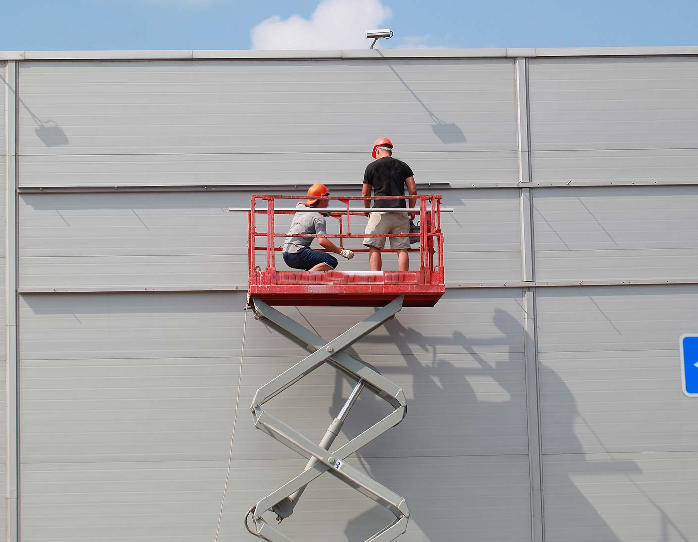 Arbeiter auf Hebebühne an einer Gebäudewand